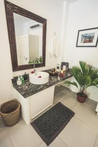 a bathroom with a sink and a mirror at Evolution Dive and Beach Resort in Malapascua Island