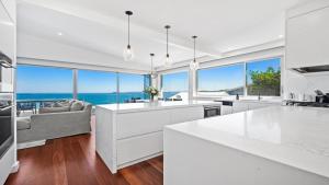 a white kitchen with a view of the ocean at 'Sea Mist' by HolidayCo in Hardys Bay