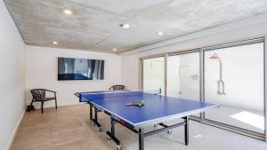 a blue ping pong table in a room with a table at 'Sea Mist' by HolidayCo in Hardys Bay +16 photos