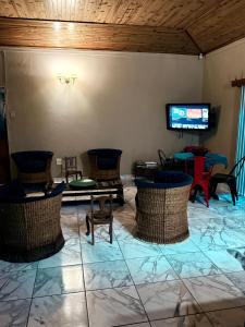 a room with chairs and tables and a tv at El Roi apartment in Middelburg
