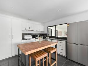 a kitchen with white cabinets and a wooden counter top at Stylish Family Retreat by Hawley Beach in Hawley Beach