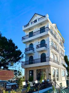 un alto edificio bianco con balconi di Lotus Hotel Đà Lạt a Khu Chi Lăng