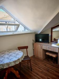 a room with a table and a tv and a window at Дом Бакалски-Кмета in Narechenski Bani +23 photos