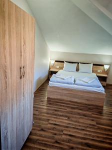 a bedroom with a bed and a large wooden door at Дом Бакалски-Кмета in Narechenski Bani