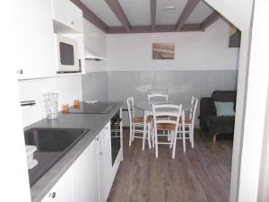 a kitchen and dining room with a table and chairs at Charmante maisonnette proche plage - Animaux admis - FR-1-823-117 in Barbâtre