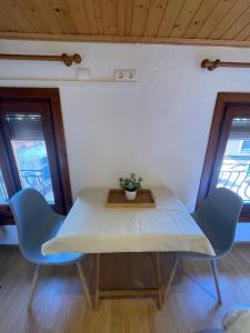 a table and chairs in a room with windows at EVA & TRAVEL - CAL MARCEL - Habitacion in Prades