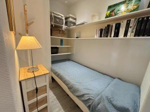 a small bedroom with a bed and a lamp at Charmant 2 pièces à Hendaye avec WiFi - FR-1-239-1105 in Hendaye