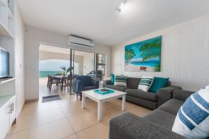 a living room with a couch and a table at 4 Skiathos-family holiday home with breaker views in Ballito