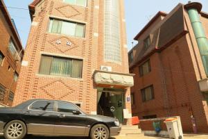 a black car parked in front of a brick building at Seoul Holiday Guesthouse in Seoul