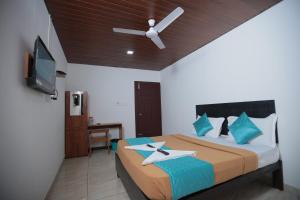 une chambre avec un lit avec un ventilateur de plafond dans l'établissement GEM Suites, à Cochin