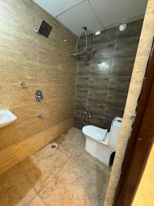 a bathroom with a shower and a toilet and a sink at Hotel Elite Enclave in Hyderabad