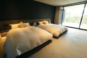 a bedroom with two beds and a large window at KITOW private villa in Awaji
