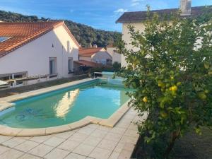 une piscine dans une cour à côté d'une maison dans l'établissement Grand F4 climatisé, terrasse, garage pour 8 personnes, centre-ville Amélie-les-Bains - FR-1-703-207, à Amélie-les-Bains-Palalda