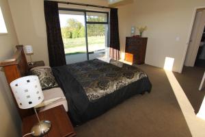 a bedroom with a bed and a large window at AislingQuoy in Amberley
