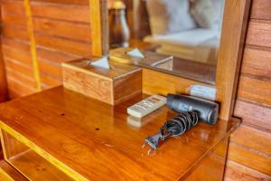 einem Glastisch mit einer Waffe und einer Fernbedienung in der Unterkunft Petak Cottage in Nusa Penida