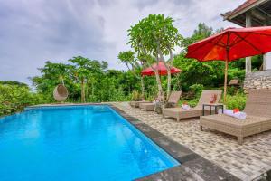 einen Pool mit Stühlen und Sonnenschirmen neben einem Resort in der Unterkunft Petak Cottage in Nusa Penida + 25 Fotos