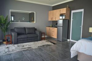 a living room with a couch and a refrigerator at Hartklop Luxury Self Catering Guesthouse in Linkside