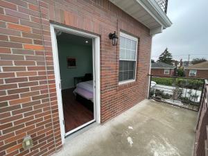 a door into a brick house with a balcony at Luxury Private room in Queens -30 min to Manhattan in Woodhaven