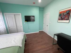 a bedroom with a bed and a tv on the wall at Luxury Private room in Queens -30 min to Manhattan in Woodhaven