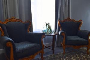 two chairs and a table in a room with a window at Hartklop Luxury Self Catering Guesthouse in Linkside