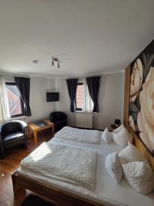 a bedroom with a bed and a living room at Pension Gisela in Gößweinstein