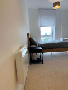 a bedroom with a bed and a radiator and a window at Two-Bedroom Apartment with City View in Birmingham