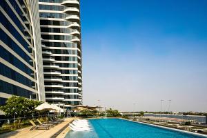 a swimming pool in front of a tall building at Capital Suites Hotel & Residences in Abu Dhabi