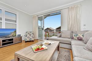 un soggiorno con un divano e un tavolo di Coastal Breeze at Caves Beach Villas a Caves Beach