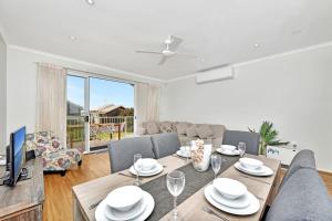 un soggiorno con tavolo da pranzo e televisione di Coastal Breeze at Caves Beach Villas a Caves Beach