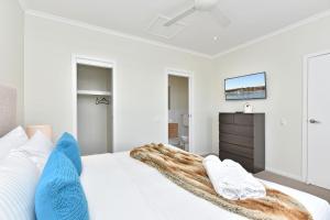 una camera da letto con un letto bianco con una coperta sopra di Coastal Breeze at Caves Beach Villas a Caves Beach Altre 29 foto