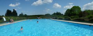 a group of people swimming in a large swimming pool at Ferienhaus Freilingen in Blankenheim