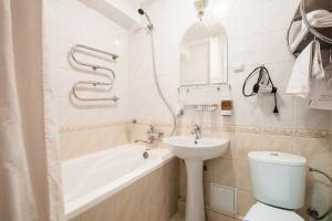 a bathroom with a sink, toilet and bathtub at Bukovyna Hotel in Chernivtsi