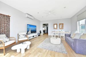 a living room with a couch and a table at Blue Lagoon at Caves Beach Villas in Caves Beach