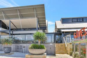 a building with two potted plants in front of it at Blue Lagoon at Caves Beach Villas in Caves Beach