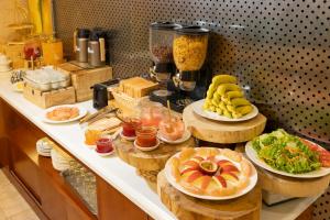 a buffet with plates of food on a counter at White Lotus Hotel Saigon in Ho Chi Minh City