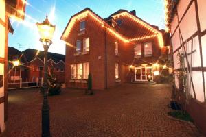 a large brick house with lights on it at Hotel Hubertus in Ennigerloh