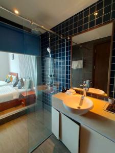 a bathroom with a sink and a shower and a bed at Chambay Bliss Retreat Mũi Né in Phan Thiet +1 photo