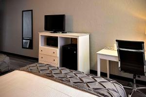 a bedroom with a tv on a stand with a desk at Heritage House Inn on Cape Cod, an Ascend Collection Hotel in Hyannis