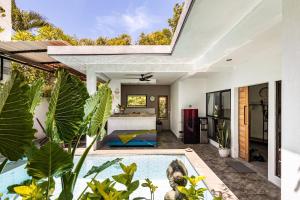 a house with a swimming pool in the middle of a yard at Villa The Jambu in Tumbak Bayuh