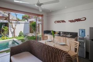 a kitchen and living room with a table and a couch at Two Lizards Beach Villas in Sanur