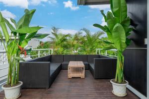 a patio with black furniture and plants on a balcony at Sahadewa 46 - Dreamland Golf Complex 4 Bedroom in Uluwatu