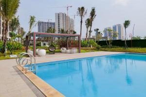 a swimming pool with a gazebo in a city at Cozy Style Studio Room at High Floor Sky House BSD Apartment By Travelio in Tangerang