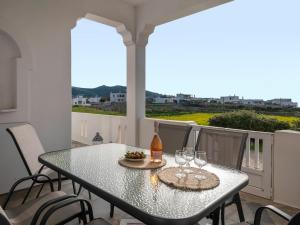 una mesa con una botella de vino y copas en el balcón en Three Wishes !, en Parasporos