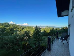 a balcony with two chairs and a view of a field at Zeleni kutak in Sarajevo