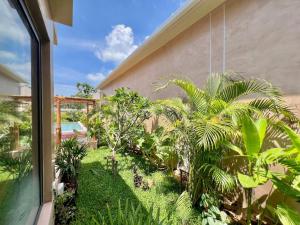 a garden with palm trees and plants next to a building at Villa Terracotta 2 - 3 Bedrooms - Lamai Coconut Grove in Ban Lamai