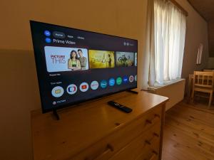 a flat screen tv sitting on top of a wooden dresser at Makovna - Apartmán Západ in Tři Sekery