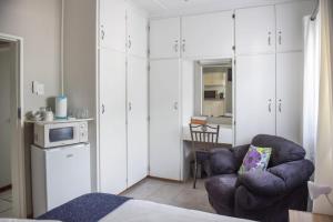 ein Wohnzimmer mit einem Stuhl und einer Mikrowelle in der Unterkunft Webbs Self catering Cottage in Vryheid