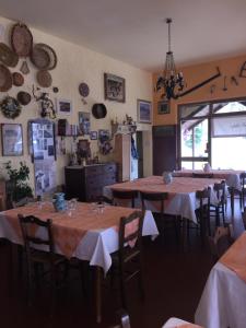 a dining room with tables and chairs and a kitchen at Albergo Ristorante La Selva in Orsigna
