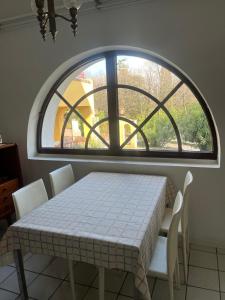a table and chairs in a room with a large window at Villa Maria Callas Sirmione in Sirmione