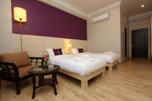 Tempat tidur dalam kamar di Hotel Harmika